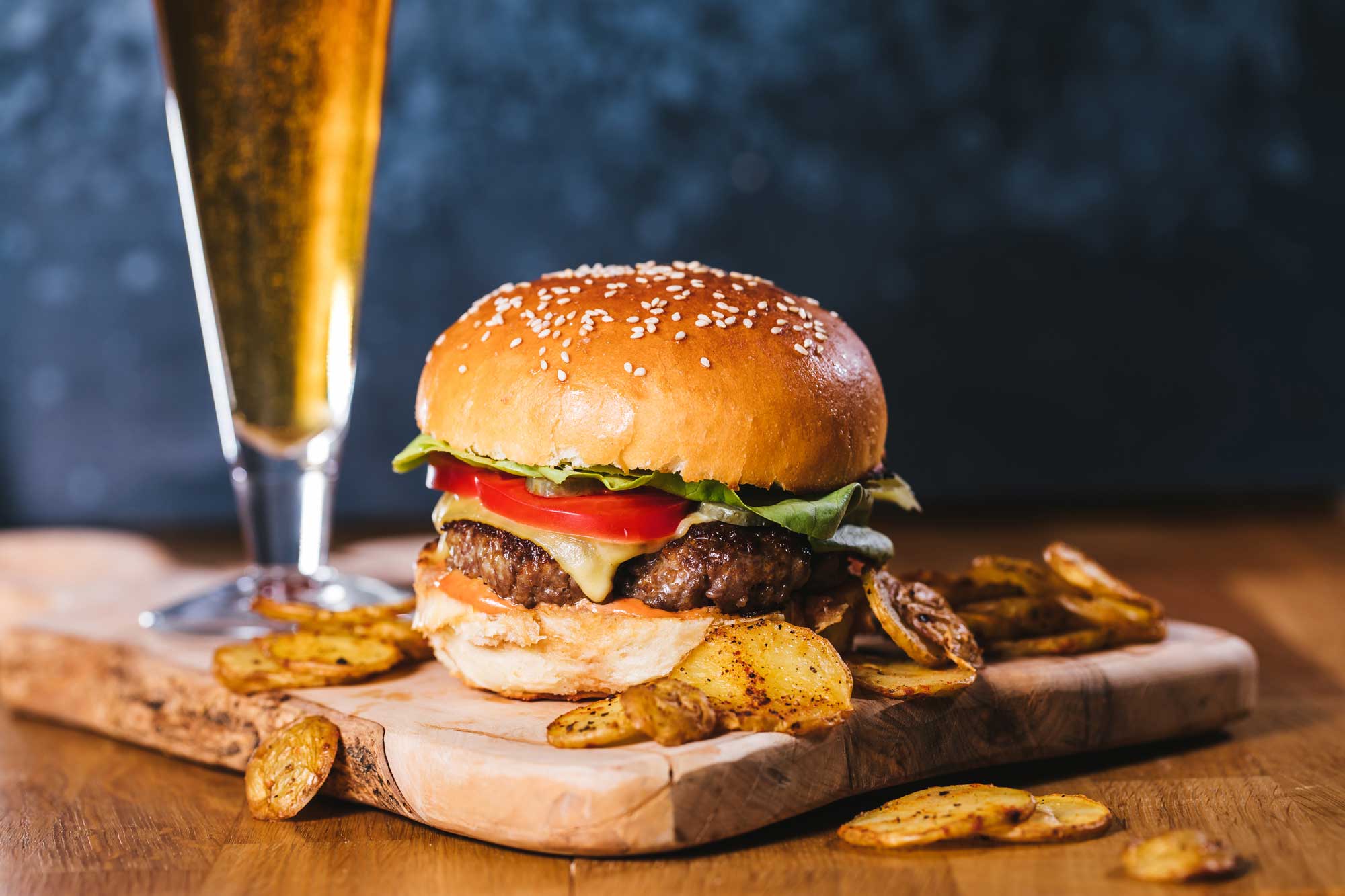 AdobeStock_436584895_web Ein saftiger Burger mit einem Glas Bier dazu