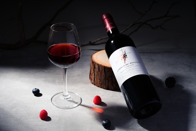 Eine Flasche Rotwein mit Beeren als Deko.